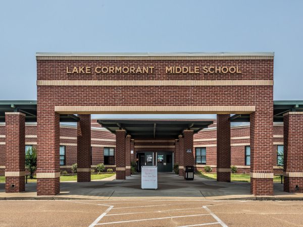 The welcoming brick entrance to Lake Cormorant Middle School, featuring bold gold lettering over a covered walkway — highlighting the importance of reliable power for education and student safety.
