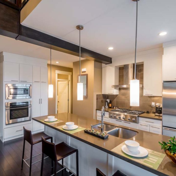 Modern, bright, clean, kitchen interior with stainless steel appliances in a luxury house