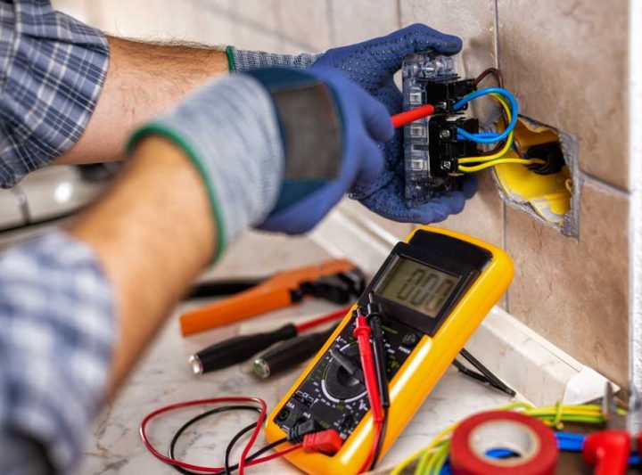 Electrician at work with screwdriver fixes the cable in the sockets of a residential electrical system