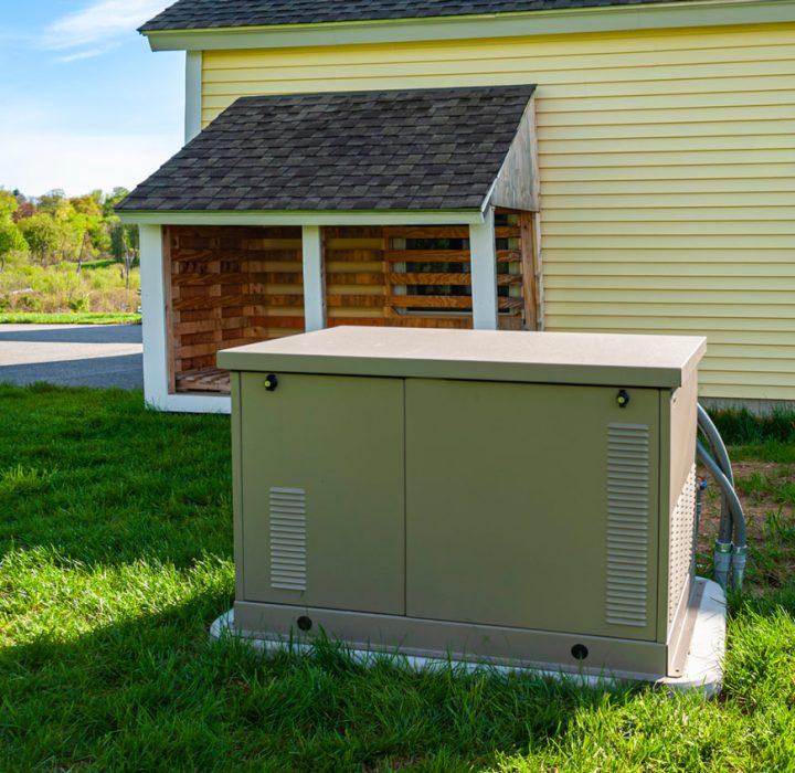 residential standby generator at the side of a house
